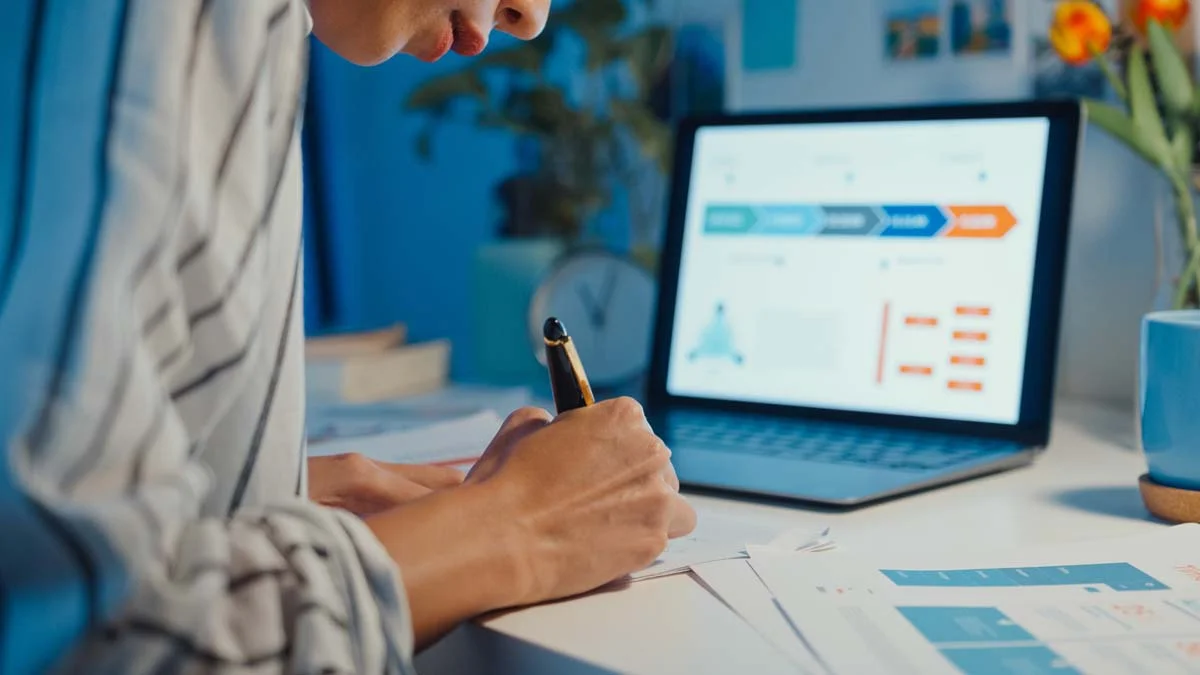 A person researching real estate and licensing requirements on a laptop in a bright modern room