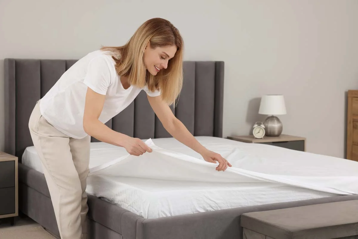 A professional property manager preparing a clean and welcoming room for a short-term rental gues