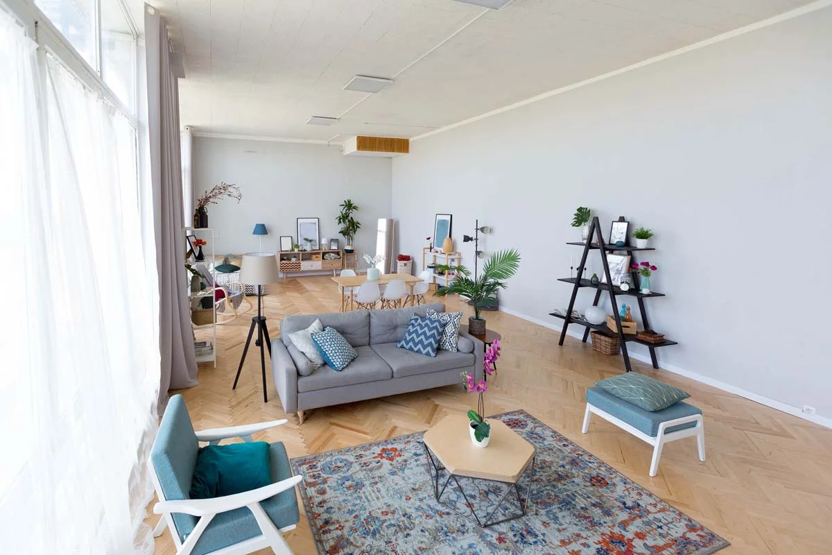 A professionally furnished modern apartment living room with neutral decor and a workspace