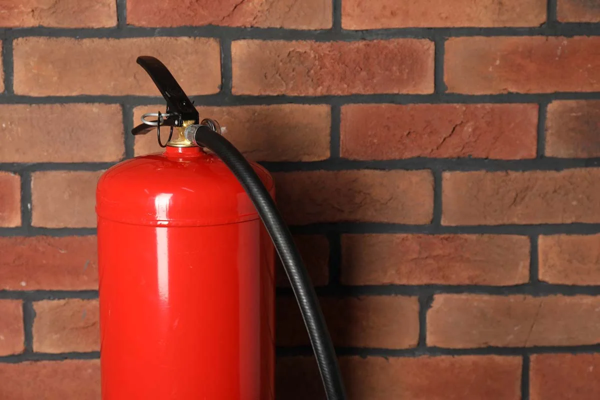A red fire extinguisher installed in a residential property for safety compliance