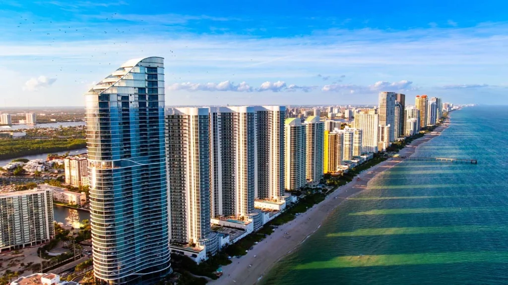 Aerial view of luxury high-rise condos along the coastline of Sunny Isles Beach Florida during a sunny day