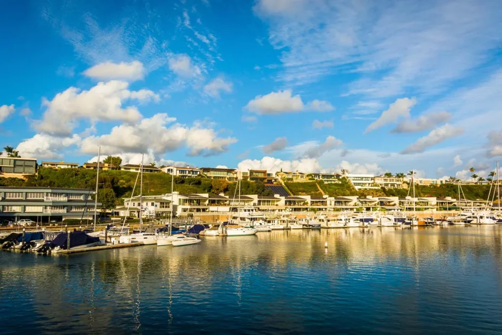 Beautiful modern coastal homes and boats in Newport Beach under a clear blue sky