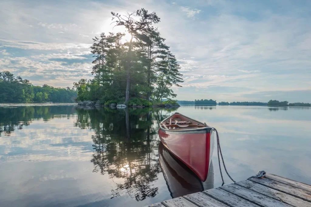 Canoe tied to a dock on the calm waters of Stony Lake representing the drive-to cottage market in Kawartha Lakes.