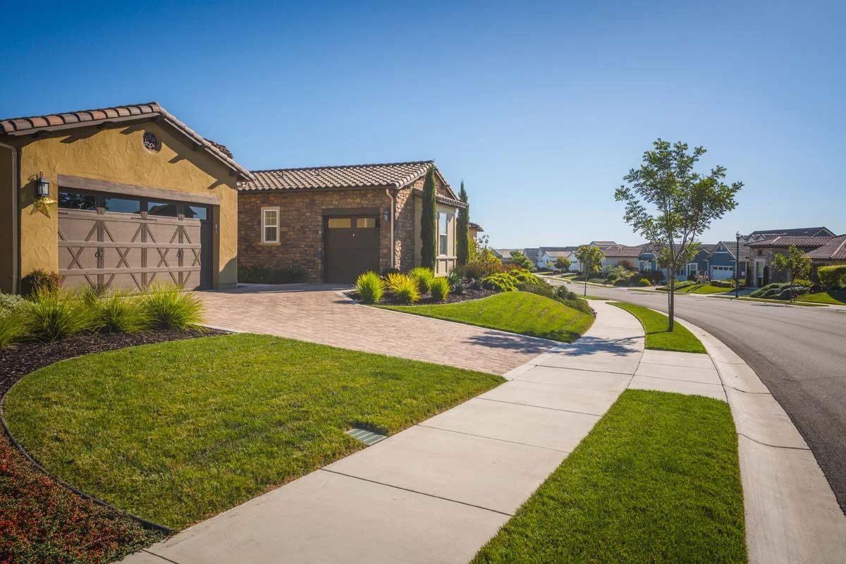 Clean empty driveway and garage attached to a residential house