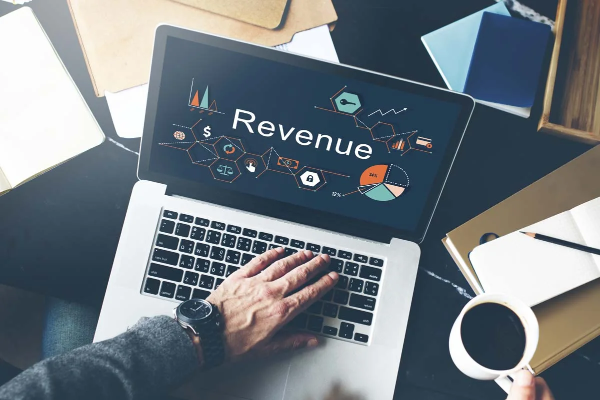 Close-up of a laptop screen showing clean revenue growth graphs on a desk