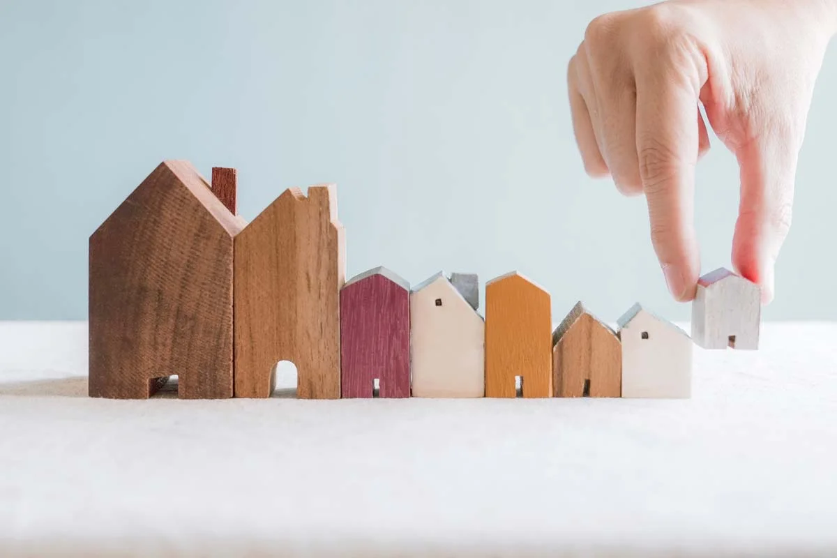 Miniature houses of different sizes, representing the need for a good marketing strategy in a large short term rental market