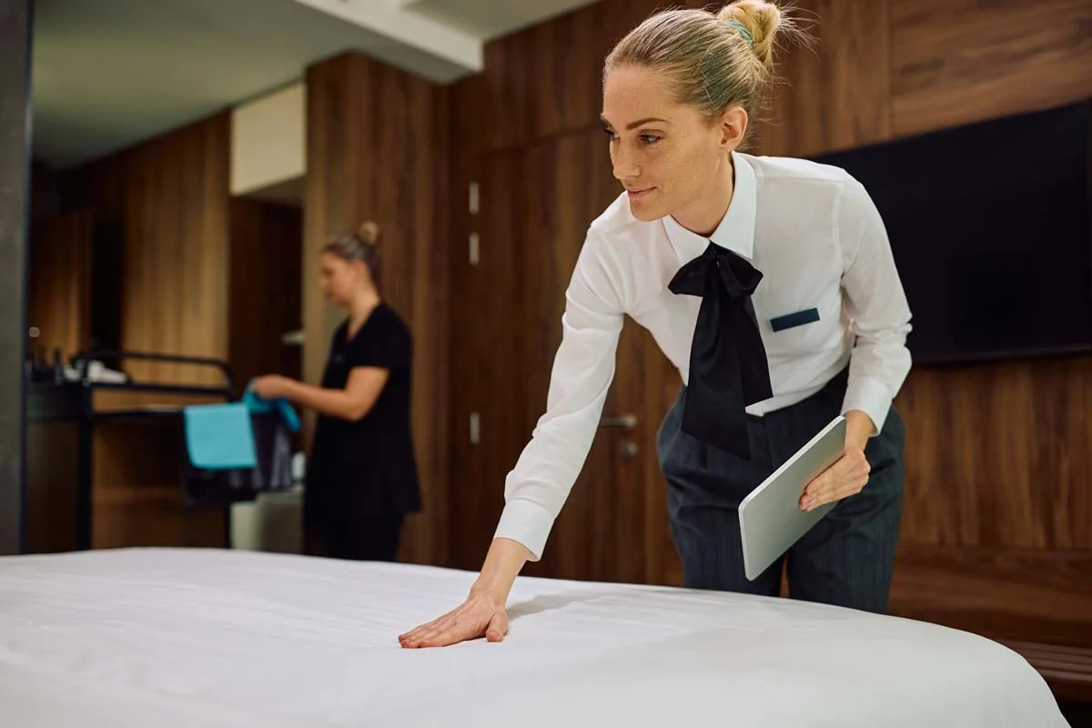 A professional cleaner using short term rental tools on a tablet to manage turnover workflows
