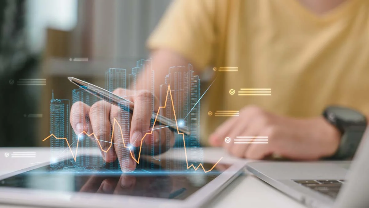 An investor analyzing property market data and housing charts on a digital tablet