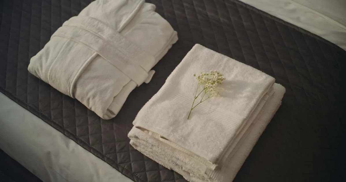 Fresh white towels neatly folded on a bed indicating high Airbnb cleaning standards