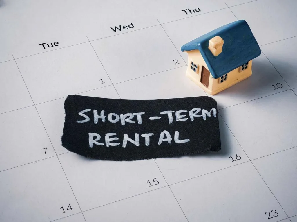 Guestable short-term rental booking concept with miniature house and calendar schedule