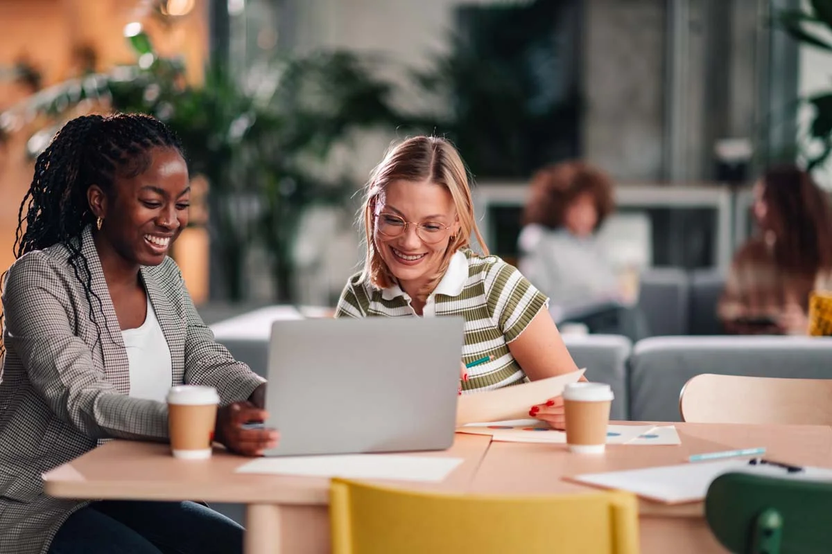 Two professionals discussing their co-hosting strategies over coffee