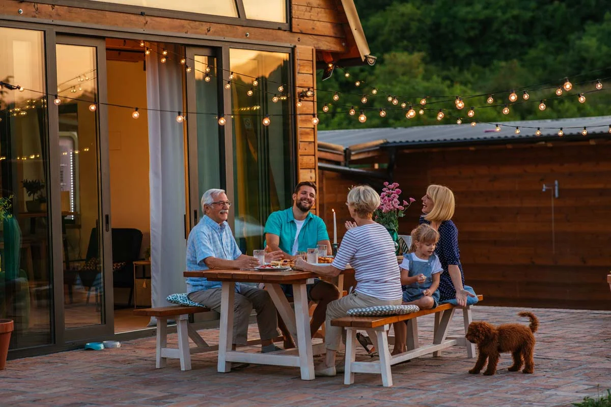 A happy multi-generational family relaxing together on an outdoor patio at a spacious vacation home rental