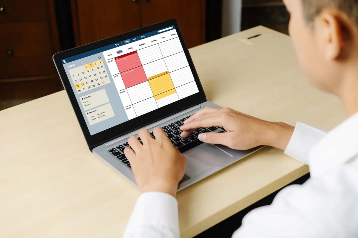A vacation rental manager using short term rental management software on a laptop