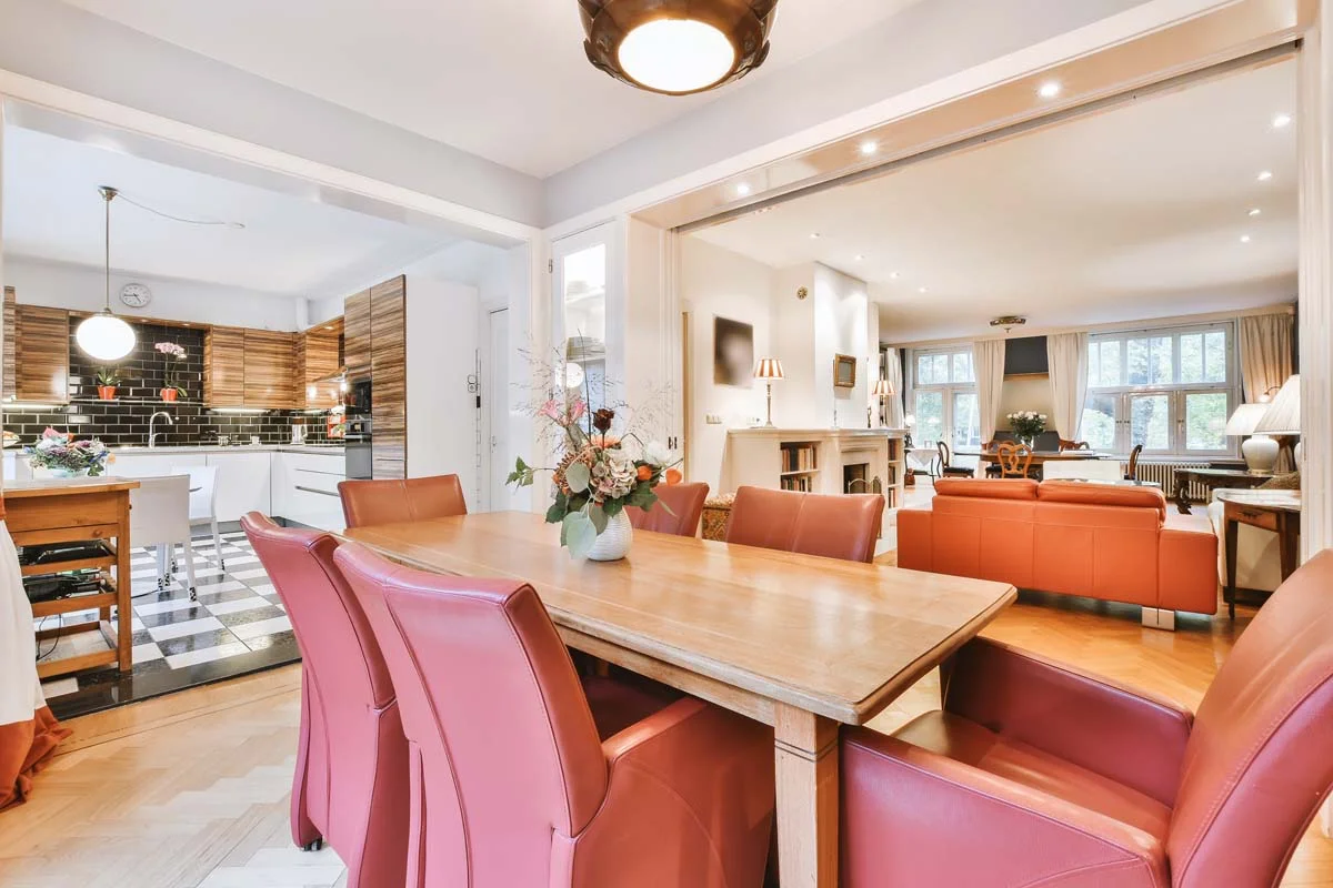 Staged and styled dining area and living room inside a modern short-term rental property, highlighting professional presentation and cozy interior design