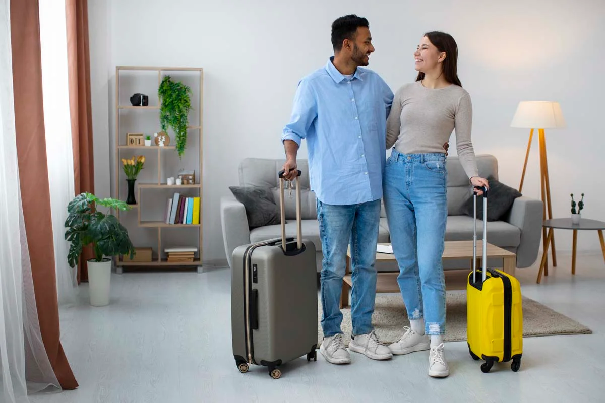 A business traveler and a casual couple arriving with luggage at a short-term rental home