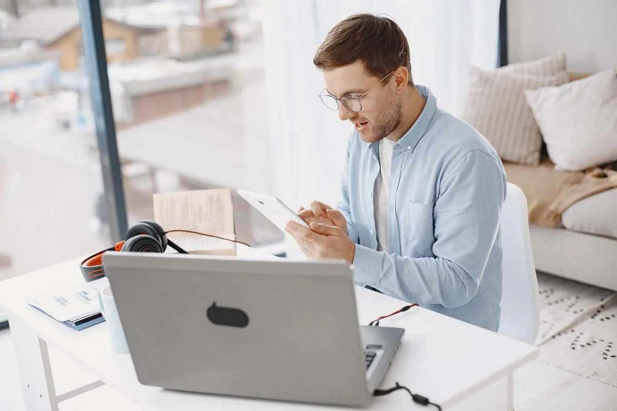 A professional property host reviewing short-term rental booking platforms on a laptop inside a modern home