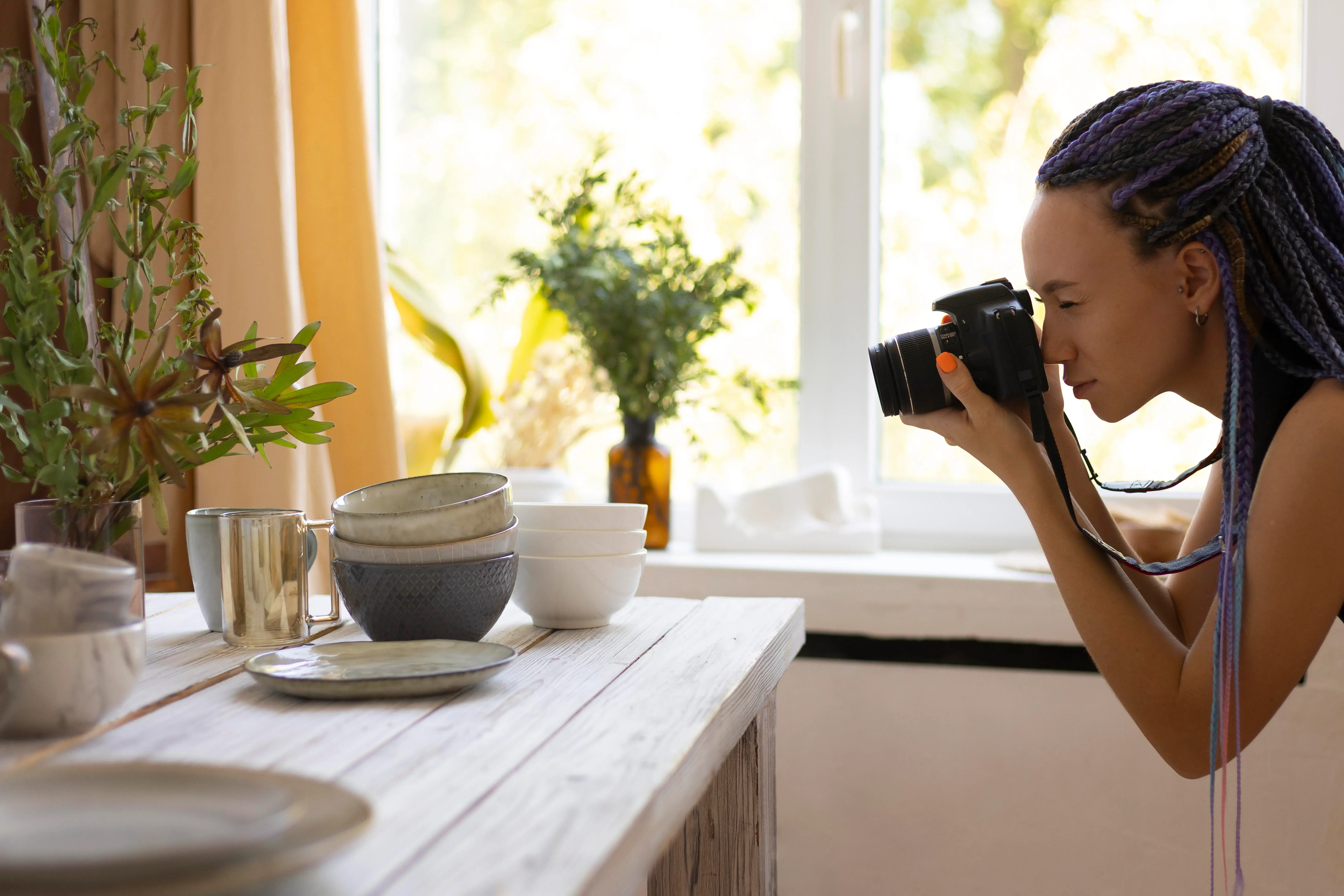 A property manager professionally staging and photographing a bright living room for an Oakville Airbnb listing