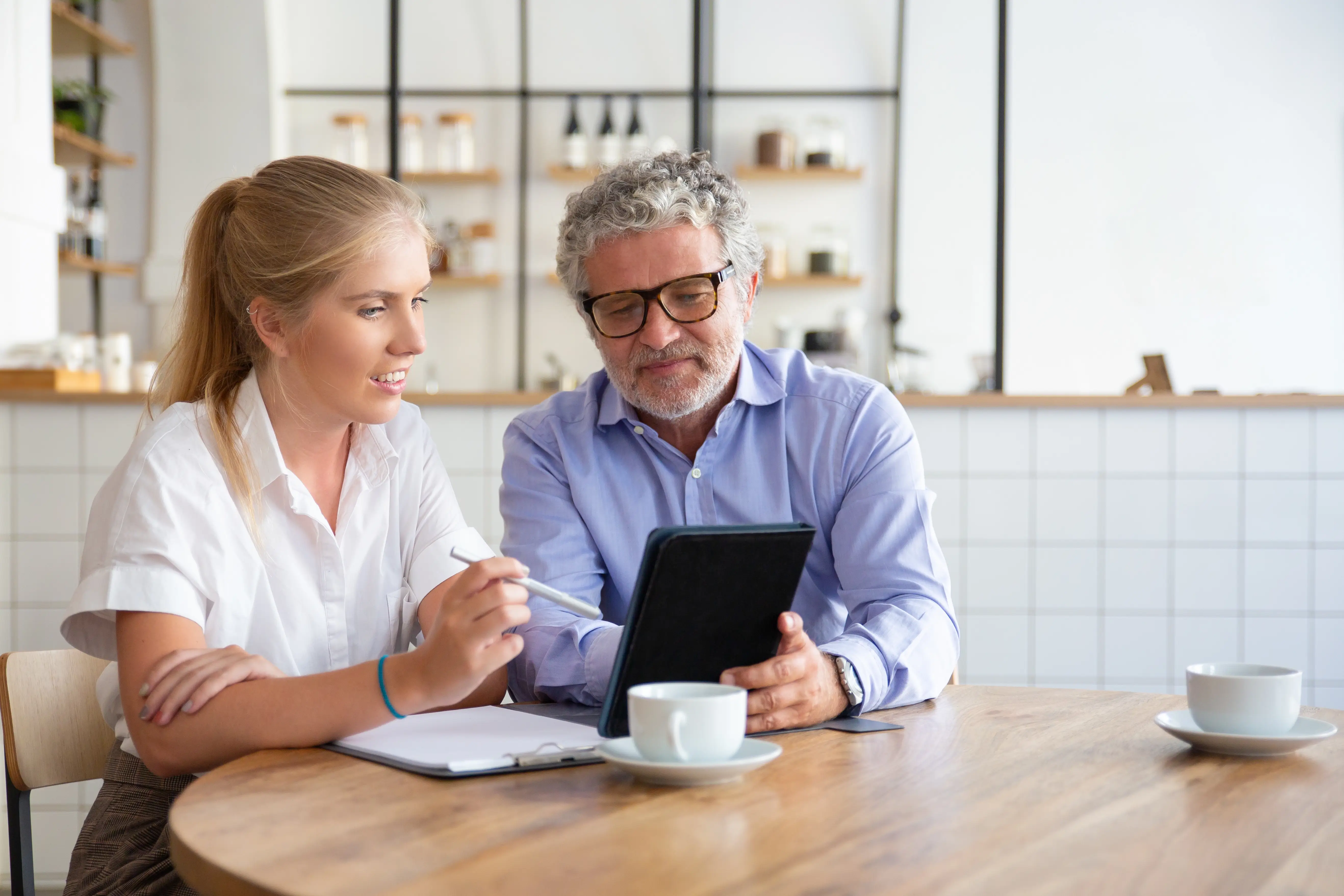 An Oakville homeowner and a property manager reviewing monthly rental revenue and compliance reports on a tablet