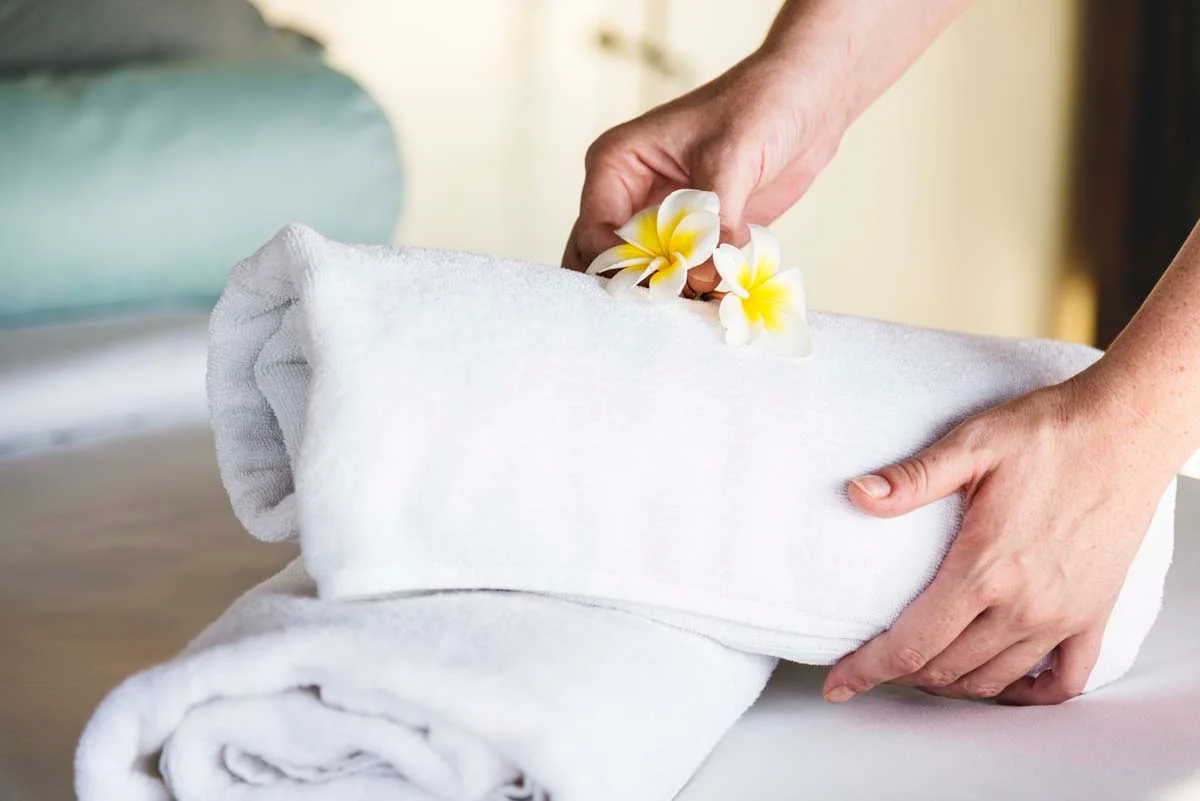 Freshly folded white towels on a bed in a vacation rental property