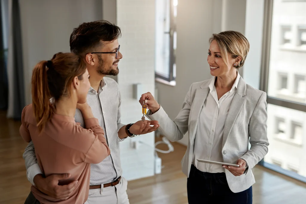 Property manager handing keys to a homeowner in a modern rental entryway