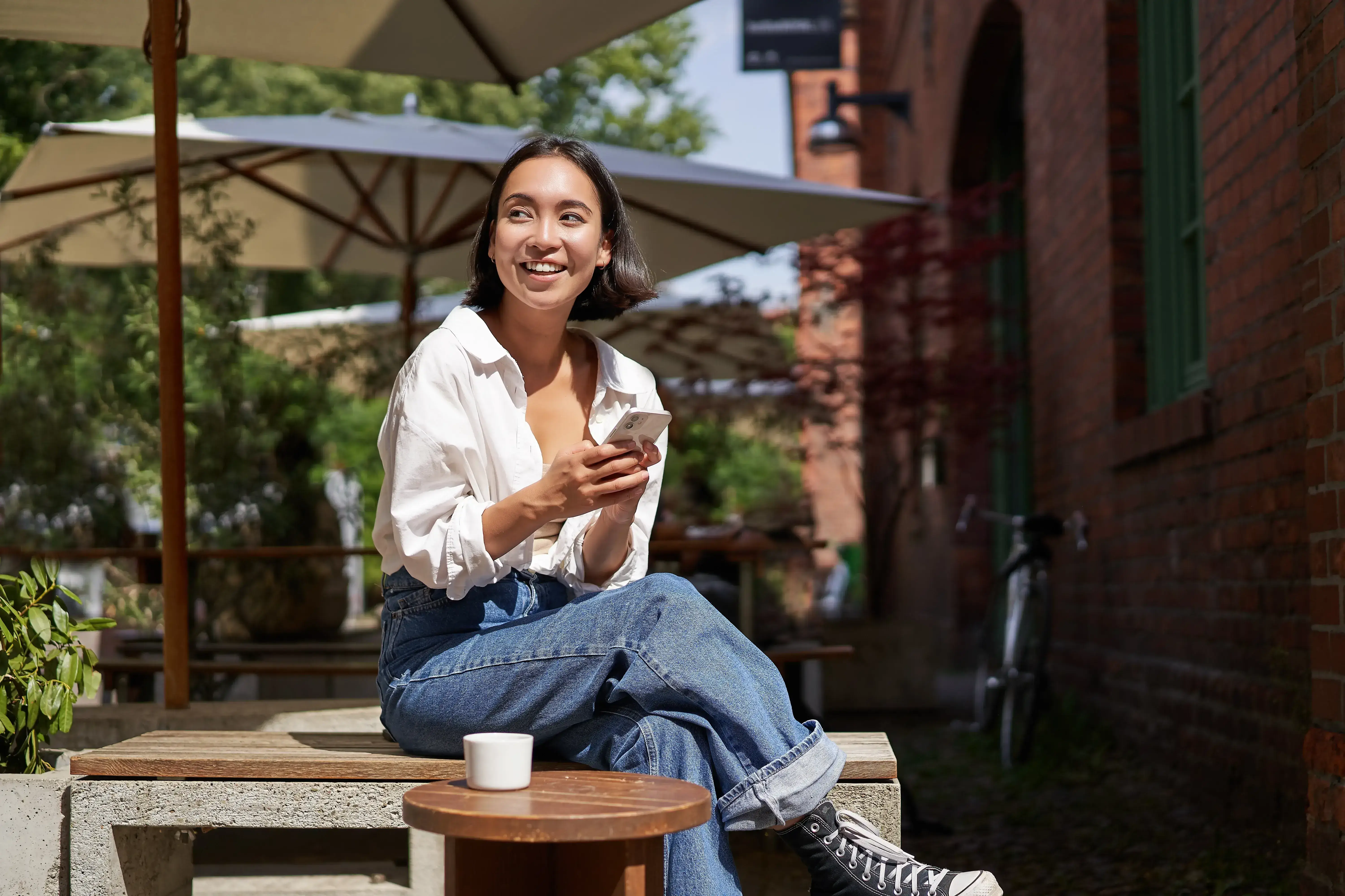 Relaxed property owner enjoying a coffee outdoors on a sunny day.