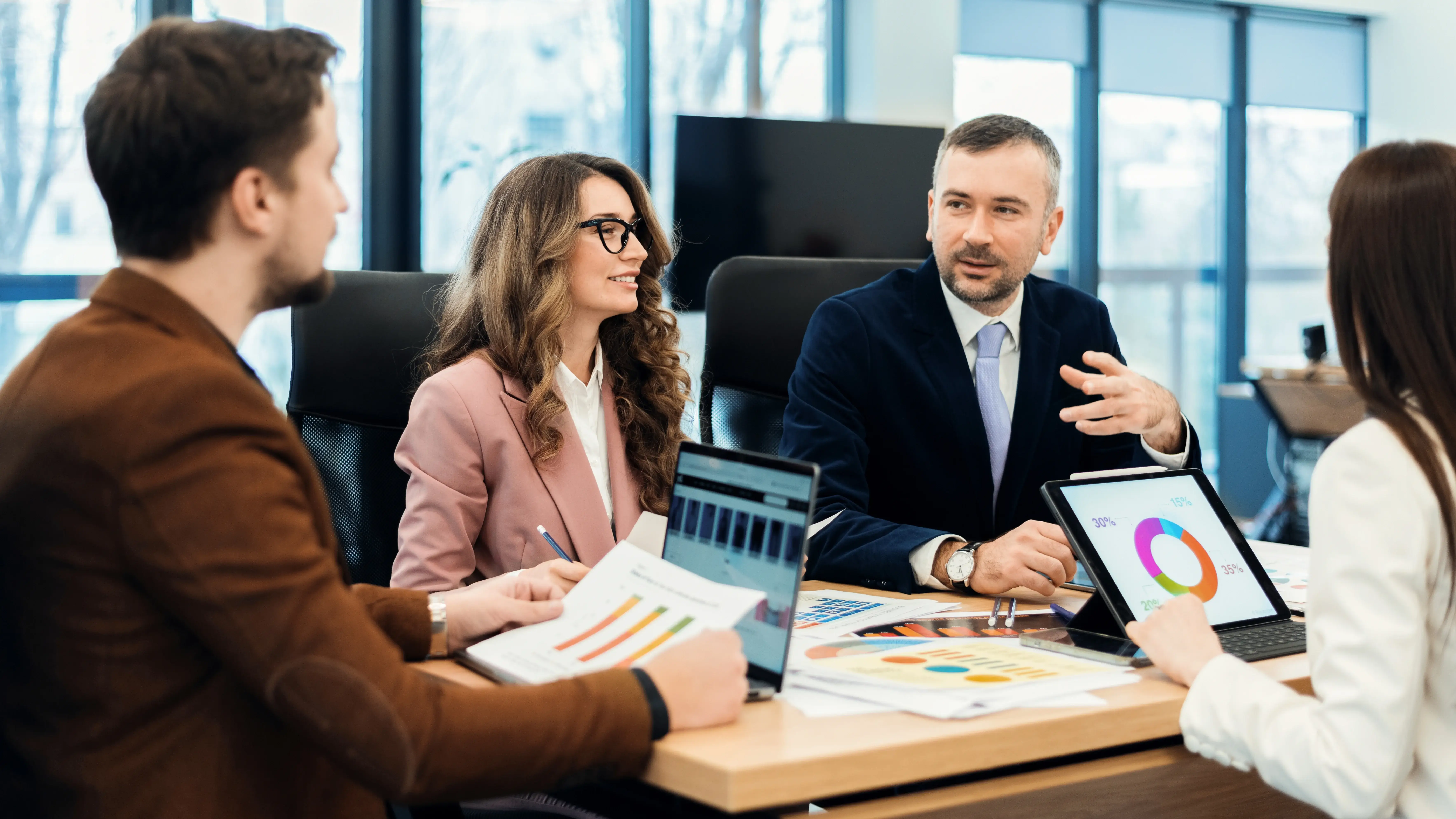 A team of marketing professionals collaborating in a conference table with one person presenting.
