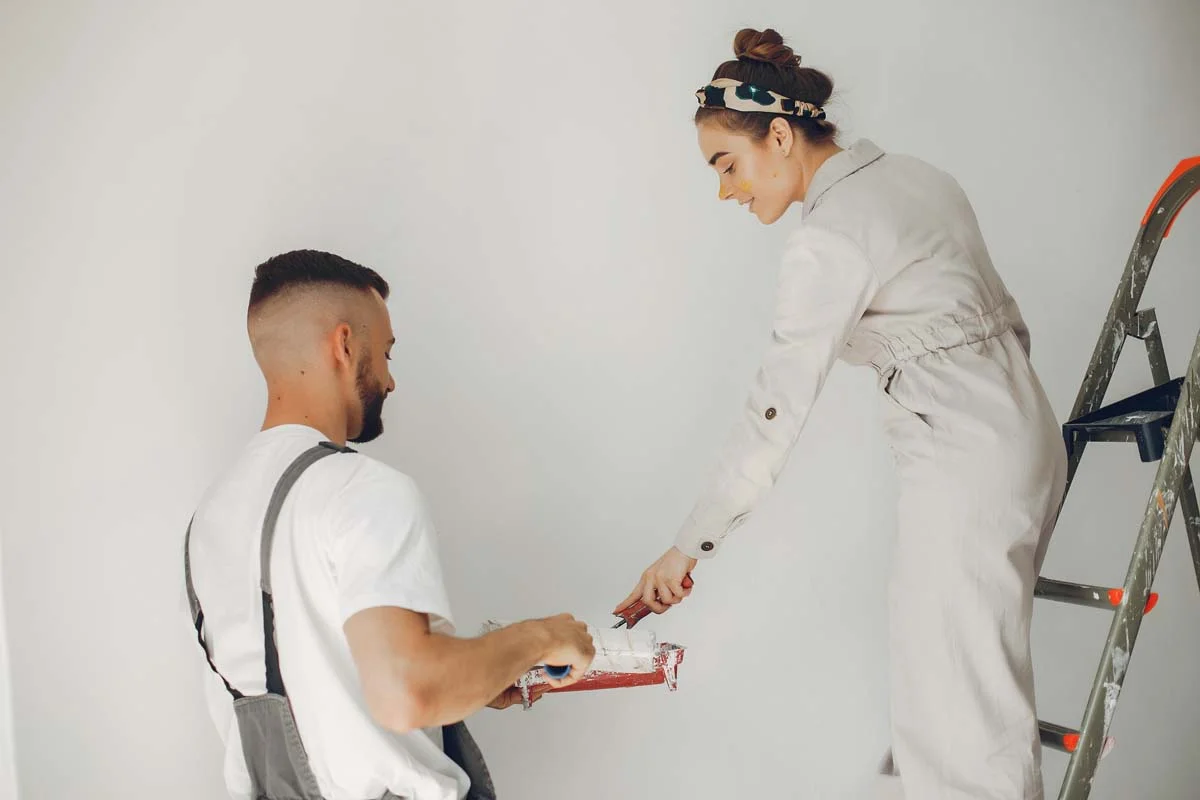 Couples painting a white room together