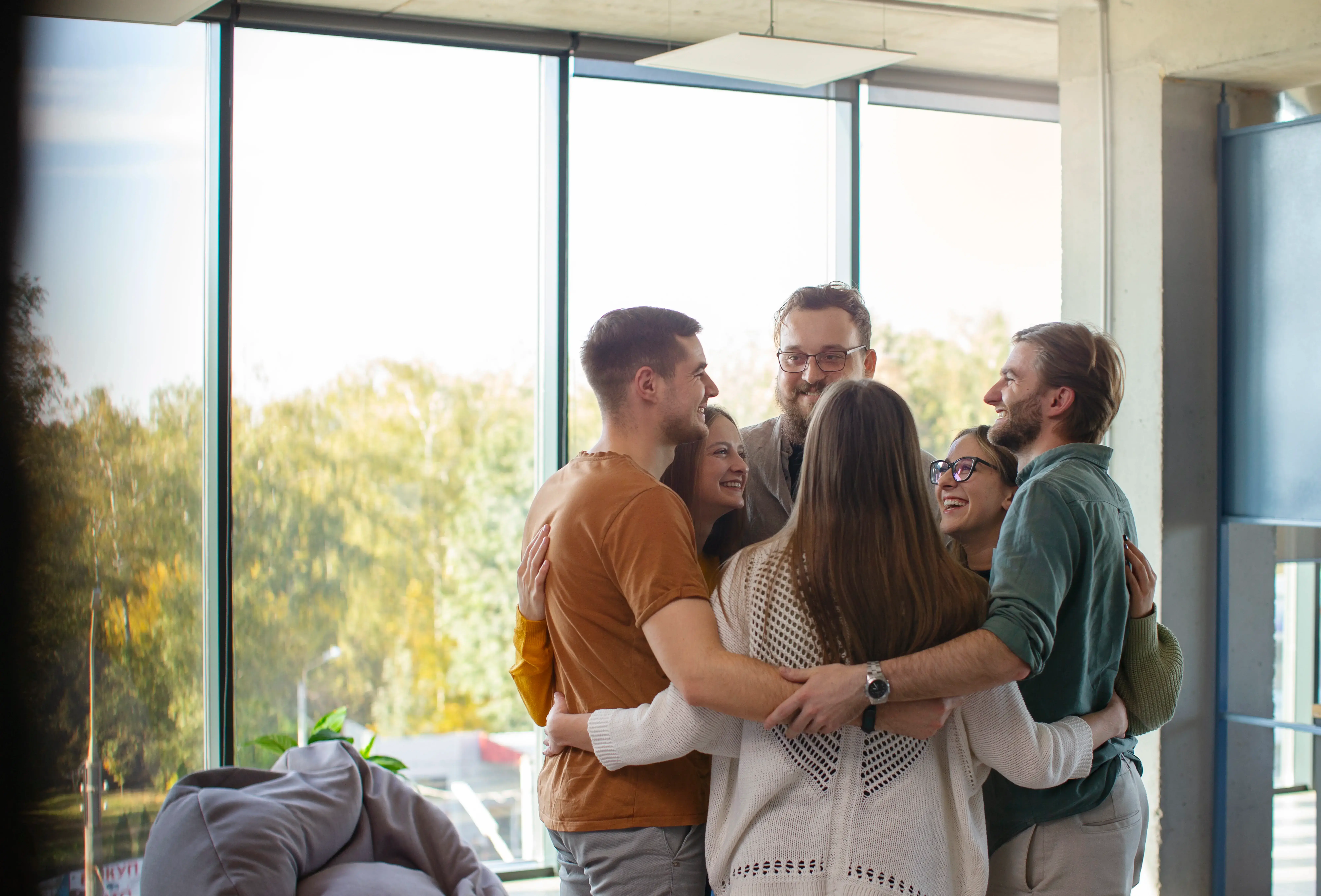Friends happily hugging and welcoming each other at a home gathering