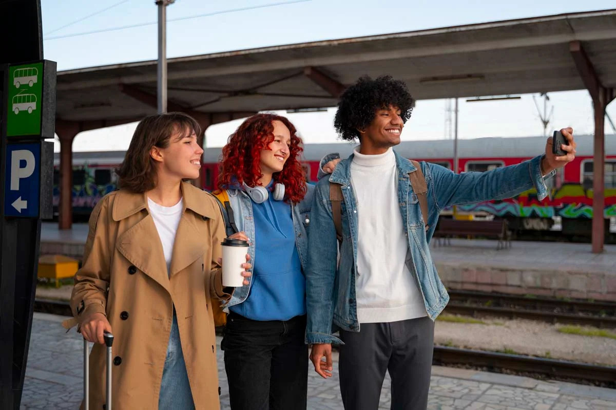 Group of diverse tourists with backpacks using a smartphone map near a city transit station