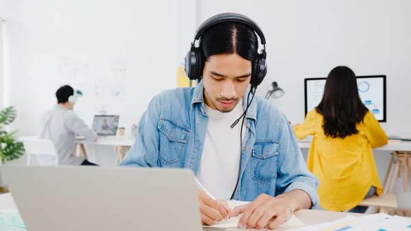 Guest support specialist responding to short-term rental inquiries on a laptop