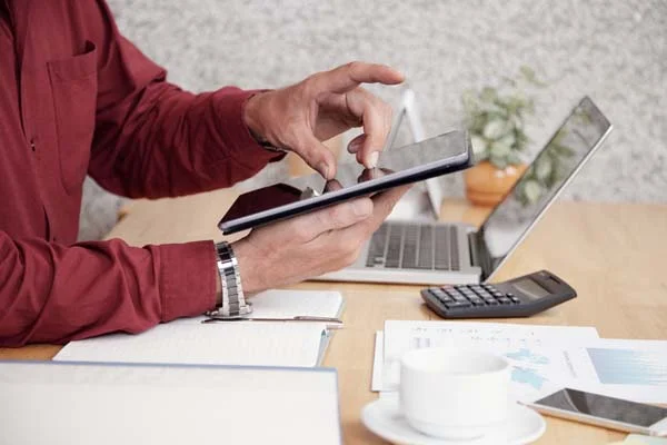 Homeowner reviewing monthly rental revenue and expense reports on a tablet