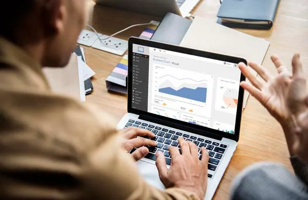Laptop screen displaying property revenue management graphs and rental booking analytics