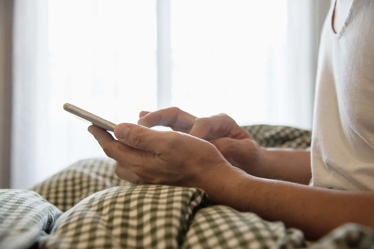 Person typing a message on a smartphone to assist a vacation rental guest