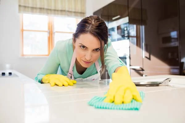 Professional cleaner tidying a modern kitchen during a property turnover