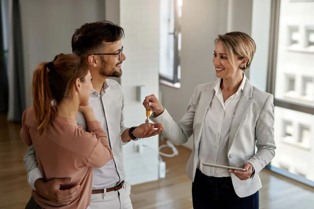 Property manager handing keys to a homeowner in a modern rental entryway