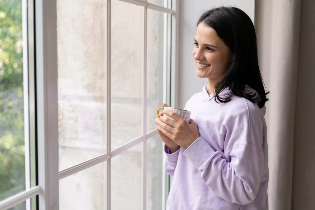 Relaxed property owner looking out a window of a managed rental home