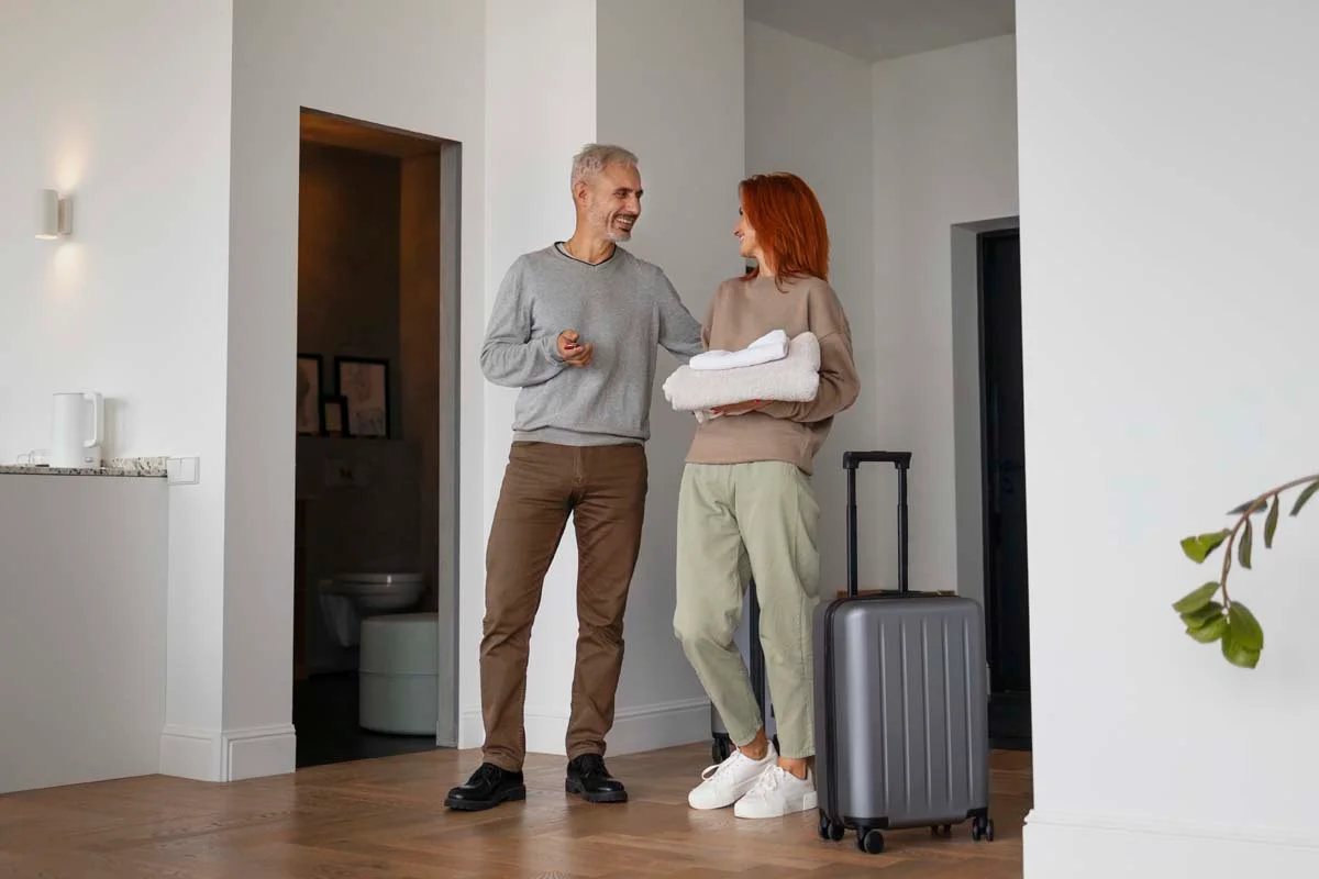 The couple entered a bright apartment with luggage.