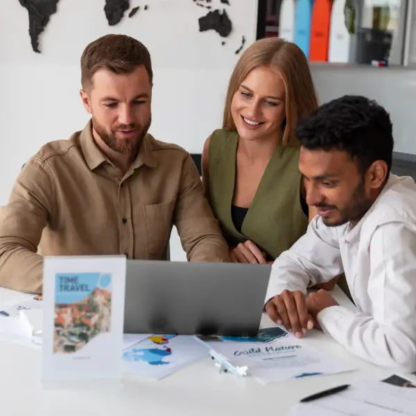 A team reviewing a vacation rental listing on laptops during a planning meeting.