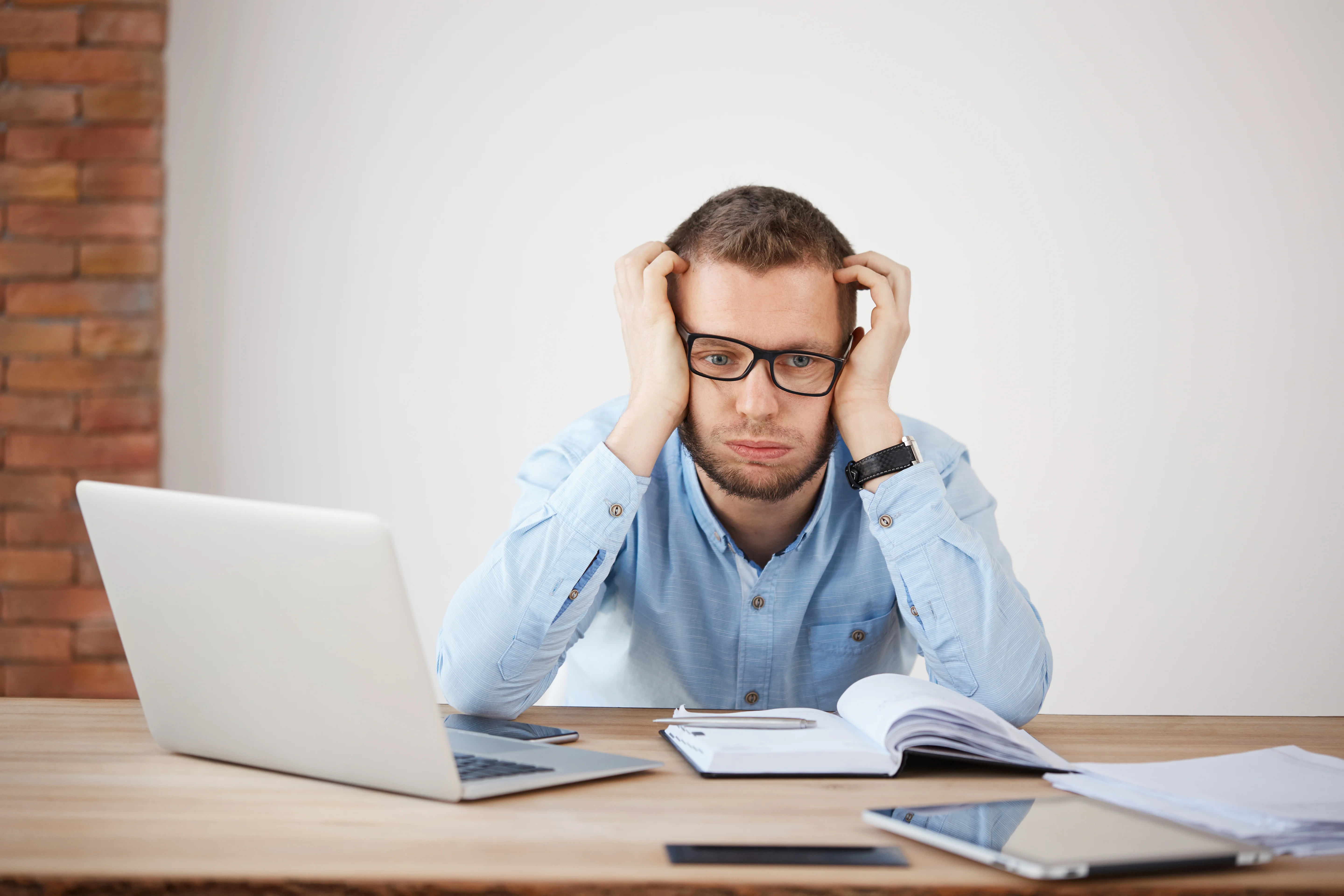 Frustrated man reviewing documents at his desk.