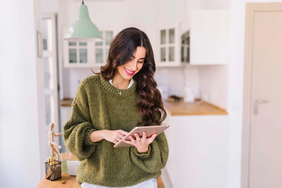 Property owner using a digital tablet to review an operational checklist inside a vacation home