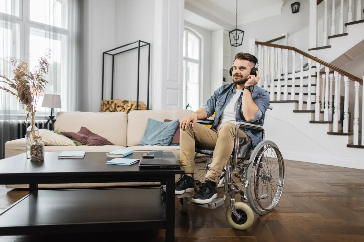 Smiling guest in a wheelchair relaxing in a bright vacation rental living room with clear floor space and natural light.